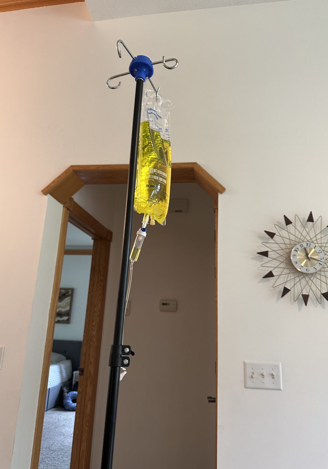 An IV pole and vitamin infusion bag set up in a client's home